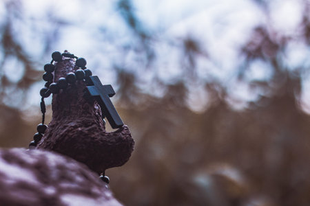 Wooden rosary with cross - with bokeh in background