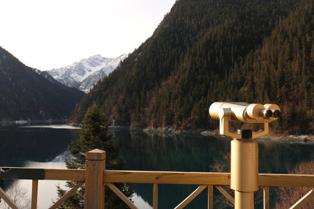 Coin operated binoculars on the background of a mountain lake.