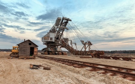 Many buckets of giant quarry excavator Equipment for the extraction of sand from the quarry. Dredge near the old railway trackの写真素材