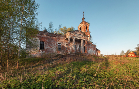 Abandoned brick orthodox church with a portico and columns at sunsetの写真素材