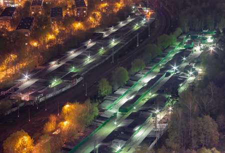 Top view car garages divided by the railroad on the outskirts of the city, at nightの写真素材