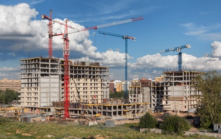 Lots of tower cranes build residential buildings at dayの写真素材