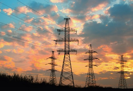 high voltage power transmission line. Silhouette electricity post on sunset backgroundの写真素材