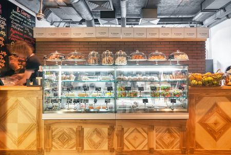 MOSCOW - AUGUST 2014: The interior gourmet cafe "IL GIORNO". Wooden cash register counter with glass showcase with dessertsのeditorial素材