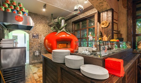 MOSCOW - AUGUST 2014: The interior Italian pizzeria "PORTO POMODORO". Open kitchen with a pizza oven in the form of tomatoのeditorial素材