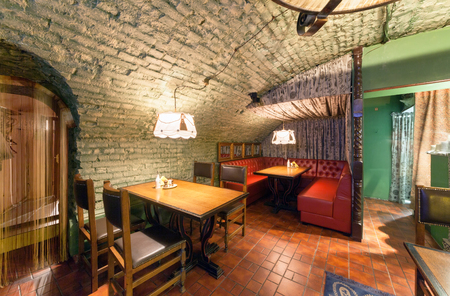 MOSCOW - AUGUST 2014: Interior of a luxury restaurant "PEPPE" in the historic cellar with brick vault. Cabinet with red leather corner sofa and tableのeditorial素材