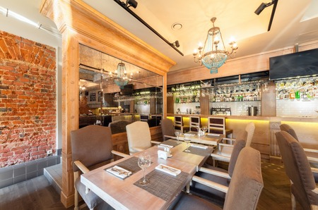 MOSCOW - AUGUST 2014: Interior elegant city restaurant "RULET" in loft style. Table near the mirror in the main hall with a barのeditorial素材