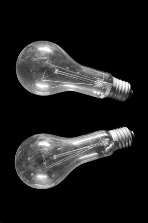 Two old incandescent bulbs covered with dust on a black backgroundの写真素材