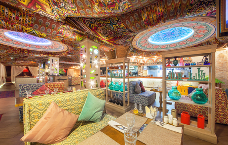 MOSCOW - AUGUST 2014: Interior Chaihana Lounge Eastern restaurant in a traditional style. The main hall with colorful fabric ceiling with ethnic patterns. Rack with glasswareのeditorial素材