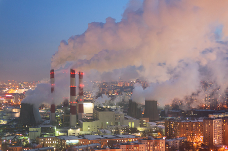 Steam and smoke from the chimneys and cooling towers city Central Heating and Power Plant. The view from the heights in the twilight, winterの写真素材