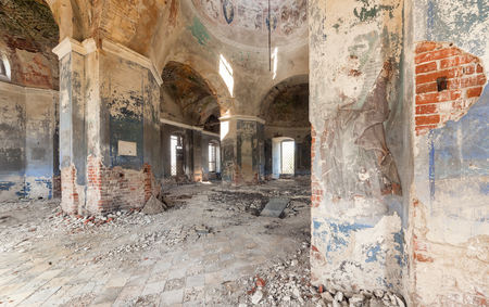 Inside an abandoned looted temple. Columns and a dome with crumbling paint and plasterの写真素材