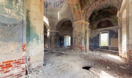 Inside an abandoned looted temple. Columns and a dome with crumbling paint and plasterの写真素材