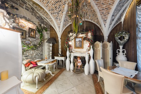 MOSCOW - AUGUST 2014: Vintage interior of the restaurant of French cuisine "Chateau de Fleurs". Hall with an arched vault, a fireplace and a doll on a wooden horseのeditorial素材