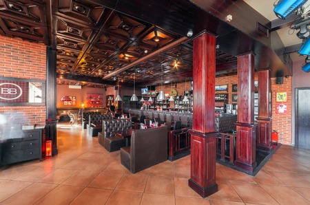 MOSCOW - AUGUST 2014: Interior of a luxury disco bar restaurant with a banquet hall and cafeteria - "BrownBar". Large restaurant bar with wooden tables and leather sofasのeditorial素材