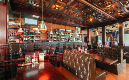 MOSCOW - AUGUST 2014: Interior of a luxury disco bar restaurant with a banquet hall and cafeteria - "BrownBar". Large restaurant bar with wooden tables and leather sofasのeditorial素材