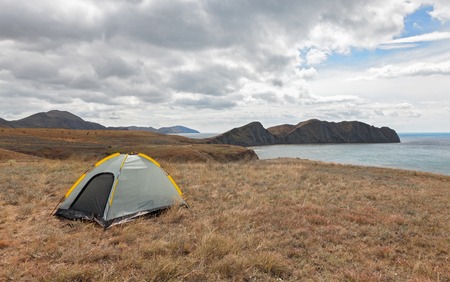 Tourist tent on a promontory near the sea of the day. The concept of traveling with tentsの写真素材