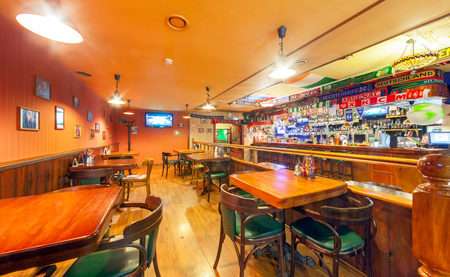 MOSCOW - AUGUST 2014: The interior of the Irish pub and the sports bar "Boston". The main hall with wooden furniture, sports attributes and a giant bar counter with drinksのeditorial素材