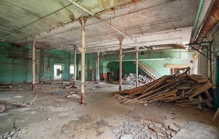 Destroyed production room of an old abandoned textile factory with remains of broken equipmentの写真素材