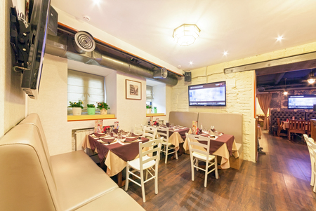 MOSCOW - AUGUST 2014: The interior of the beer bar "SHTIRBEERLITZ". Beige hall with fitted tables with ceiling ventilationのeditorial素材
