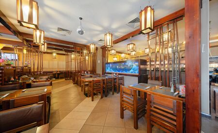 MOSCOW - SEPTEMBER 2014: The interior of the popular Japanese chain of restaurants "YAKITORIYA" in Moscow. A table for visitors near the aquarium. Modern design with traditional Japanese styleのeditorial素材