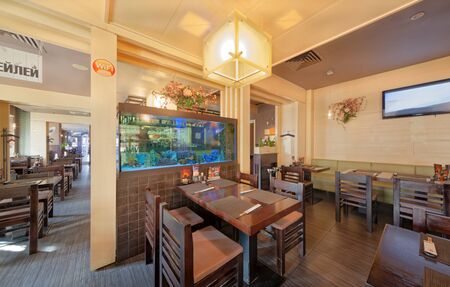 MOSCOW - SEPTEMBER 2014: The interior of the popular Japanese chain of restaurants "YAKITORIYA" in Moscow. A table for visitors near the aquarium. Modern design with traditional Japanese styleのeditorial素材