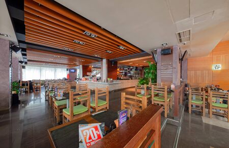 MOSCOW - SEPTEMBER 2014: The interior of the popular Japanese chain of restaurants "YAKITORIYA" in Moscow. Hall without visitors with wooden furniture. Modern design with traditional Japanese styleのeditorial素材