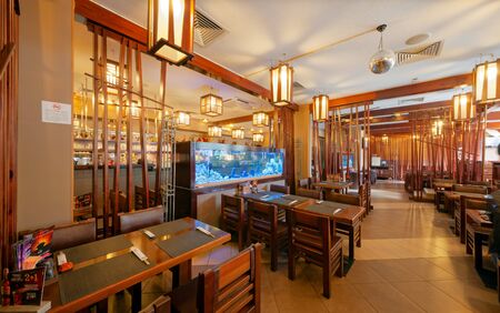 MOSCOW - SEPTEMBER 2014: The interior of the popular Japanese chain of restaurants "YAKITORIYA" in Moscow. A table for visitors near the aquarium. Modern design with traditional Japanese styleのeditorial素材