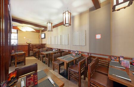 MOSCOW - SEPTEMBER 2014: The interior of the popular Japanese chain of restaurants "YAKITORIYA" in Moscow. Hall without visitors with wooden furniture. Modern design with traditional Japanese styleのeditorial素材