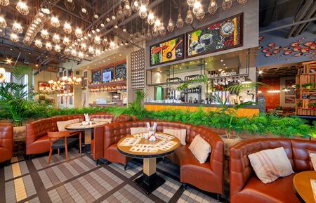 MOSCOW - OCTOBER 2014: The interior of the trendy restaurant "Oki Doki". Hall with semicircular leather sofas, bar counter and open kitchenのeditorial素材