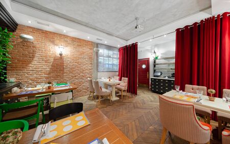 MOSCOW - OCTOBER 2014: The interior of the restaurant of Eastern European cuisine "Spices & Joy". Cozy room with wooden parquet and red curtainsのeditorial素材
