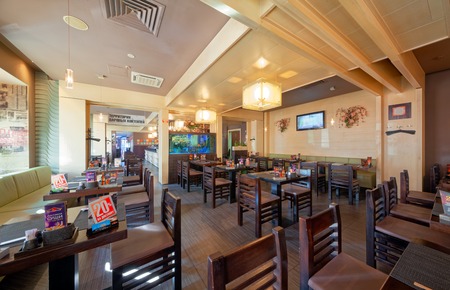 MOSCOW - SEPTEMBER 2014: The interior of the popular Japanese chain of restaurants "YAKITORIYA" in Moscow. Hall without visitors with wooden furniture. Modern design with traditional Japanese styleのeditorial素材