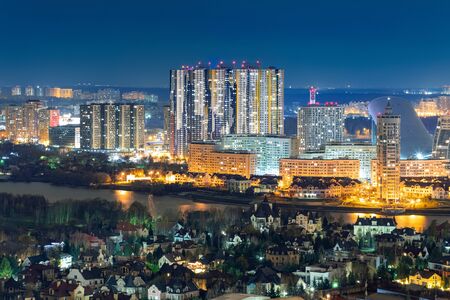 Contrast urban development separated by a river. Tall residential buildings and luxury low-rise buildingsの写真素材