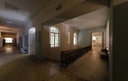 Ancient central staircase and corridor of an abandoned hospital, at nightの写真素材