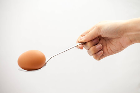 taking the egg out the water after boiling itの写真素材