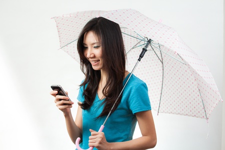 Asian women under the rain with an umbrellaの写真素材