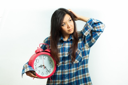 Asian woman holding an alarm clock in the  morningの写真素材