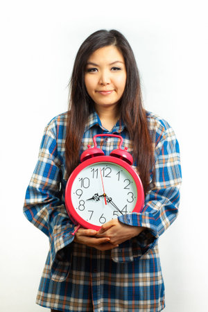 Asian woman holding an alarm clock in the  morningの写真素材