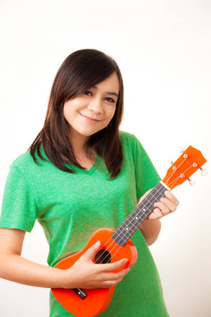 Asian woman enjoy singing with her ukuleleの写真素材