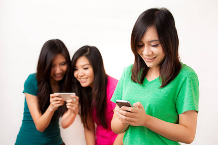 Group of Asian people enjoy their phoneの写真素材