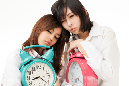 Asian woman holding an alarm clock in the  morningの写真素材