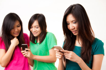 Group of Asian people enjoy their phoneの写真素材
