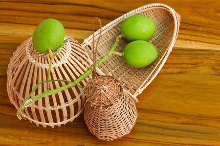 Fishing creel,coop-like trap for catching fish /Thai native equipment and mango.の写真素材