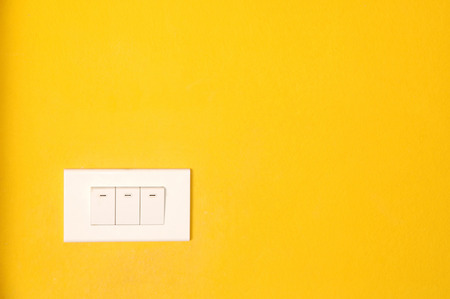 switch on a yellow wall の写真素材