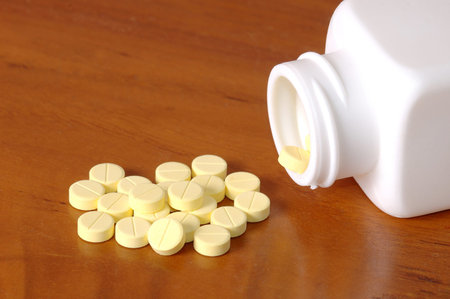 yellow pills on wooden