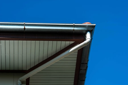 rain gutter on a roof against blue sky