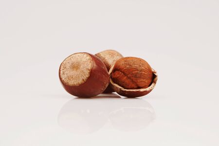 Organic and fresh two shelled and unshelled hazelnuts on white backgroundの写真素材