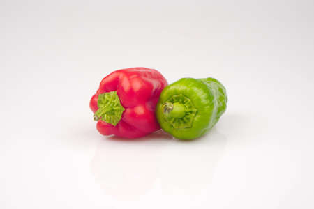 Green and red organic peppers on a white groundの写真素材