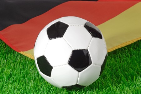 Black and white soccerball and german flag on grassの写真素材