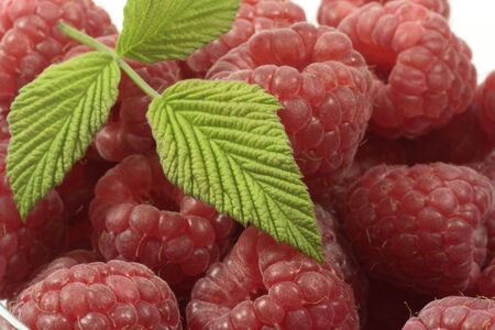 Fresh raspberries with raspberry-leaves in a glass