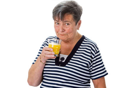 Senior woman drinking orange juice - isolatedの写真素材
